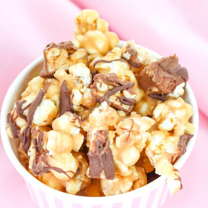 Here is a delicious popcorn recipe that is an easy dessert as well. Covered in chocolate and Snickers, this popcorn is so simple, it's crazy! Get ready to fall in love with movie night all over again thanks to this delicious homemade popcorn recipe. #popcornrecipe #dessertpopcorn #movienightfun #homemadepopcorndessert