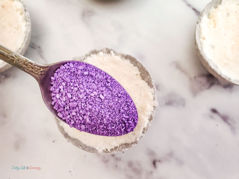 adding purple mica powder to the bath bomb 