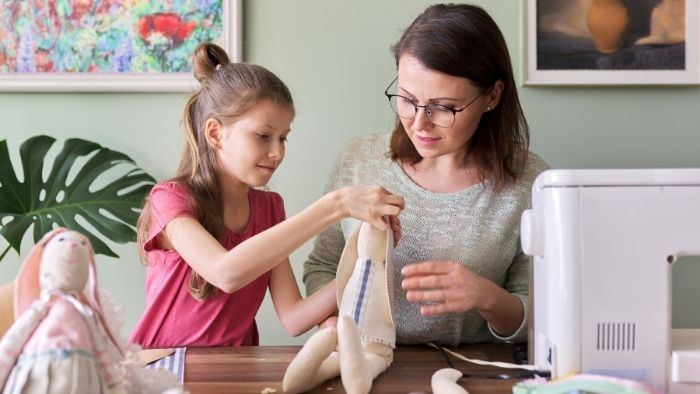 mom and child sewing toy rabbit