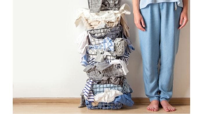 woman next to piles of laundry