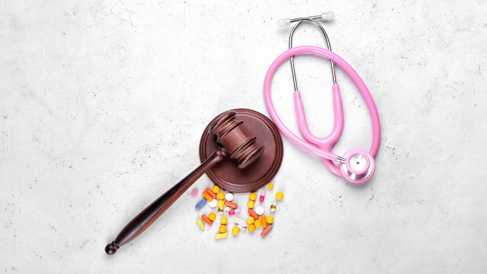 promoting health policy reform would be a great way to help women in impoverished communities. Picture is of a pink stethoscope, alongside a gavel. 